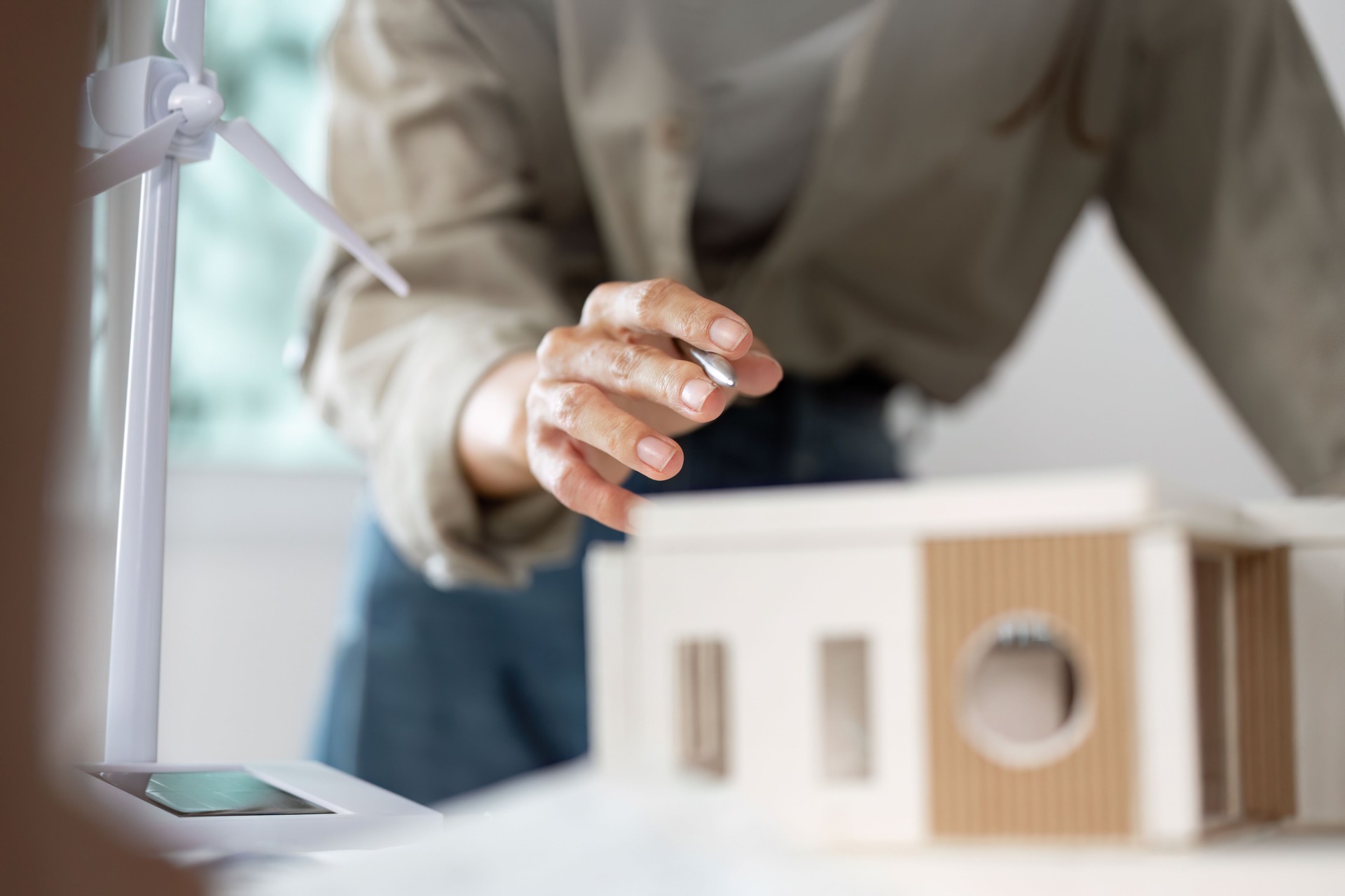 Architectural Model Creation. Close-up of hands assembling a building model with precision.